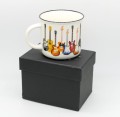 Biały kubek porcelanowy w kolorowe gitary elektryczne pakowane w czarne pudełko